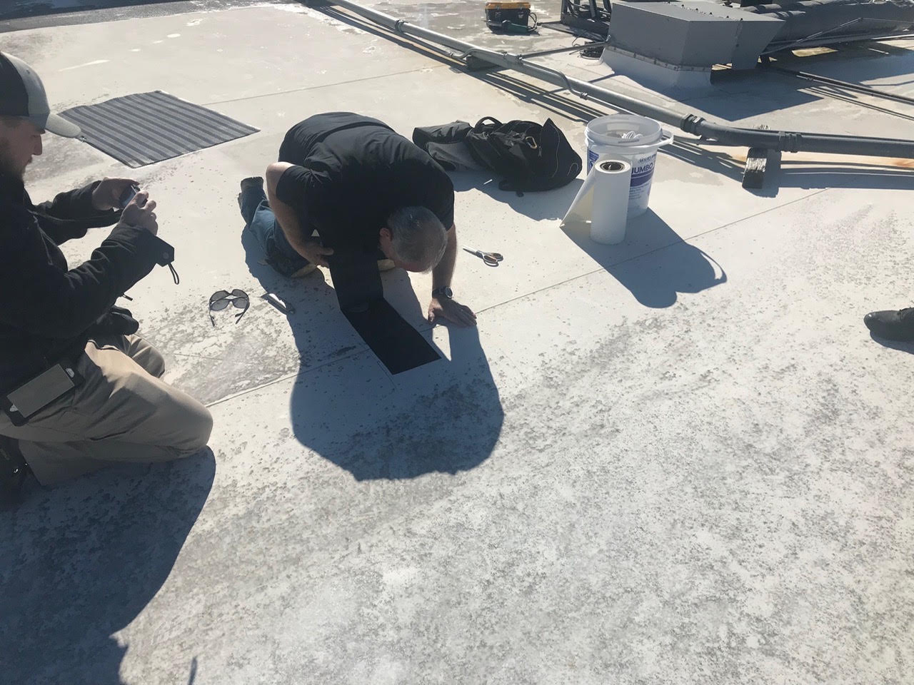 Specialists inspecting an opening in a commercial membrane roof